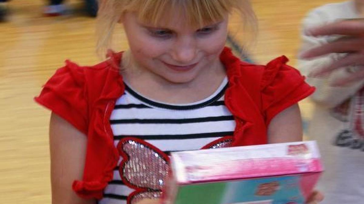 The Belleville Walmart store gave Franklin School teachers gift cards to use for their classrooms, and toys for students during an assembly on Thursday afternoon. Here, second-grader Elizabeth Ritchey-Bennett, 7, looks at a box of puzzles before she selected them as her gift. Other items included sports balls, dolls, games and two bicycles.