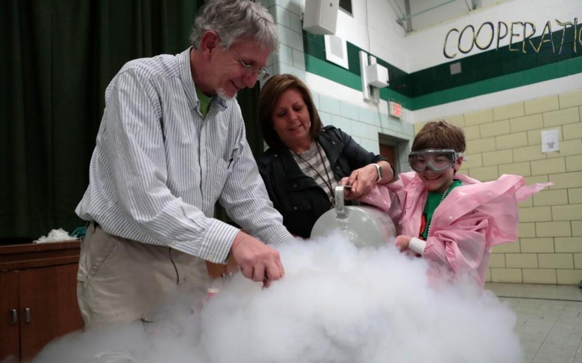 Darrell Iler, chemistry department chair and professor of chemistry at Greenville College, Diana Gravot, fourth grade teacher, and sixth grader Joyce Moorleghen make some “dry” ice cream during the family STEM night event, which took place on National Pi Day, at Douglas Elementary. Students and their families had a chance to play futuristic games and participated in other science-related activities.