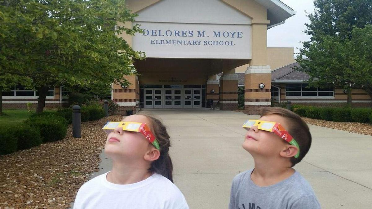 O’Fallon Community Consolidated School District 90 students Paige and Scott Stoelzle practicing using their new eclipse protective glasses in front of Delores Moye Elementary School. They are the children of Rob and Julie Stoelzle, district 90 teachers.