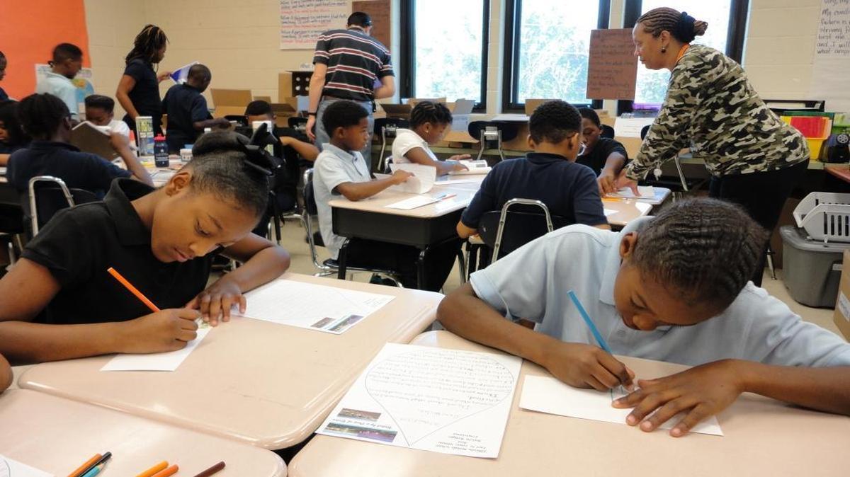 Fifth-graders at Lincoln Middle School in East St. Louis write letters to students in the Gonzales, Louisiana, area, south of Baton Rouge, who are currently displaced by summer flooding.