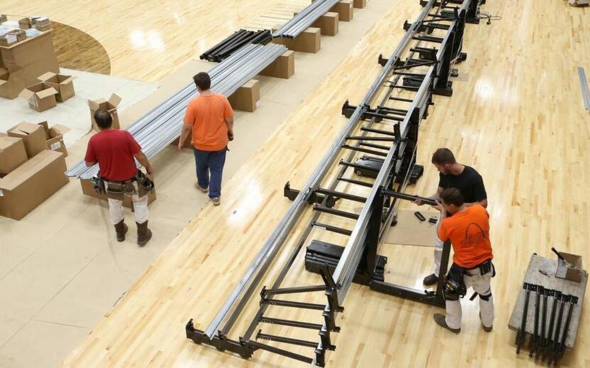 Workers install bleachers in Collinsville High School’s Fletcher Gymnasium. The district is replacing the bleachers and the gym floor. The renovation will result in less seating in the gym to account for more handicapped accessible seating.