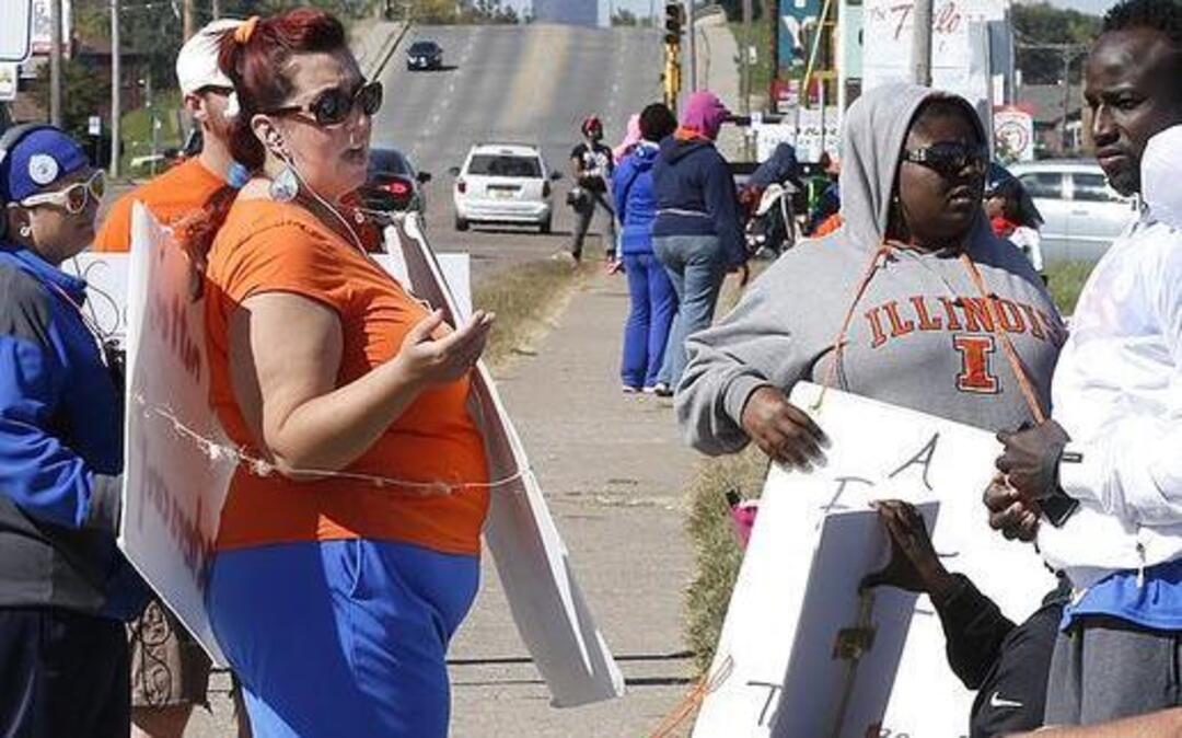
Strikers continue to march and sit on the sidewalk Tuesday in front of East St. Louis Senior High School. 
