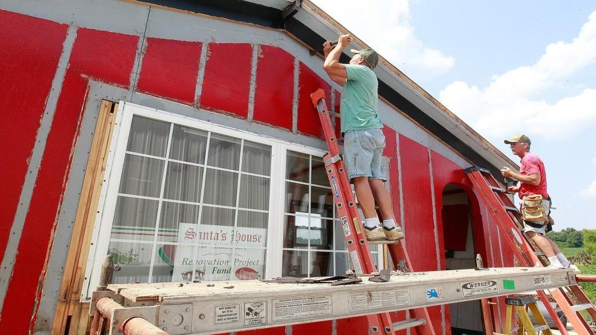 
Repair work is underway on the Belleville Santa Clause House after some rotten boards and a roof in bad shape were noticed during it's last paint job. Here, carpenter Jim Poe, left, and head carpenter Steve Dietz, both with Faber Contracting, rip off bad boards as they prepare to put on new exterior wood.

