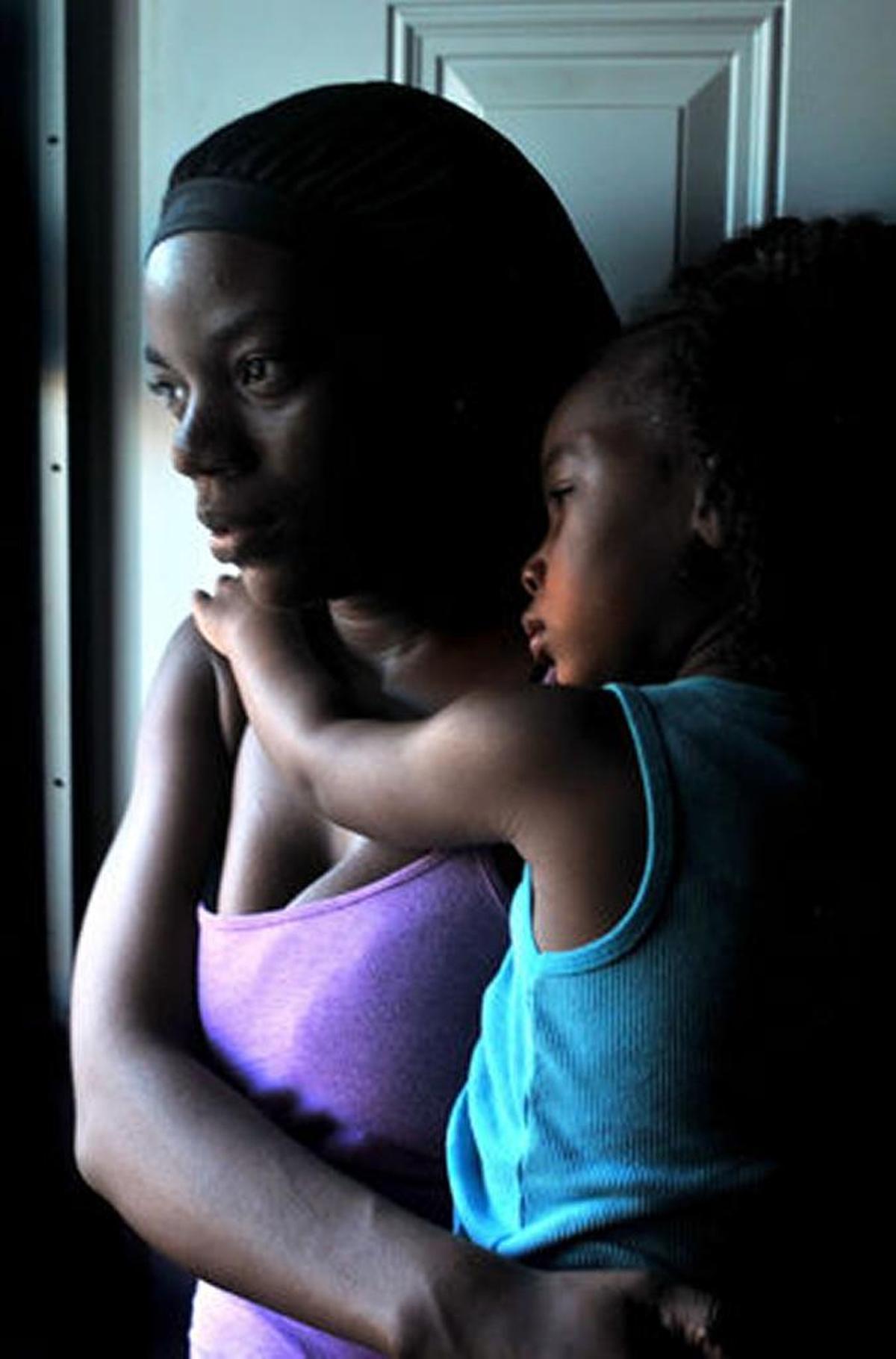 Rineka Simmons holds her daughter Da’Riyah, 3, while standing in the doorway of her Norman E. Owens apartment in East St. Louis.