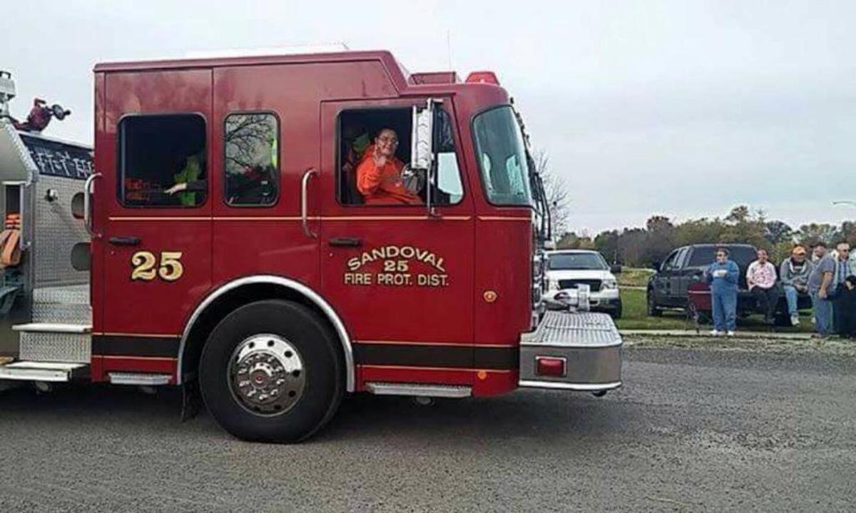 Firefighter Jason Eagan rides in a Sandoval fire truck.