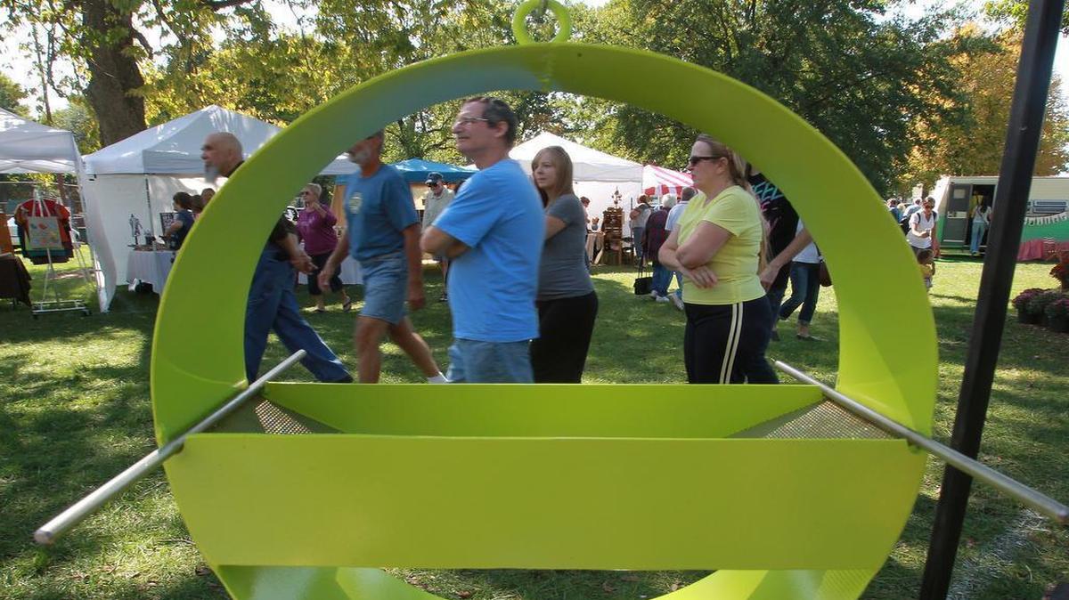 
In this file photo, visitors at the Strange Folk Festival are framed through an artistic bird feeder fabricated by one of the vendors.

