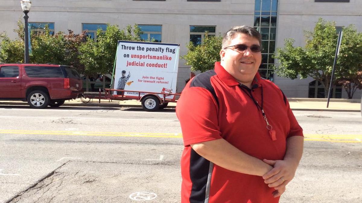 
Travis Akin of Illinois Lawsuit Abuse Watch stands in front of the traveling billboard I-LAW parked in front the Madison and St. Clair county courthouses Tuesday. I-LAW advocates for tort reform alleging lawsuit abuse in the metro-east.
