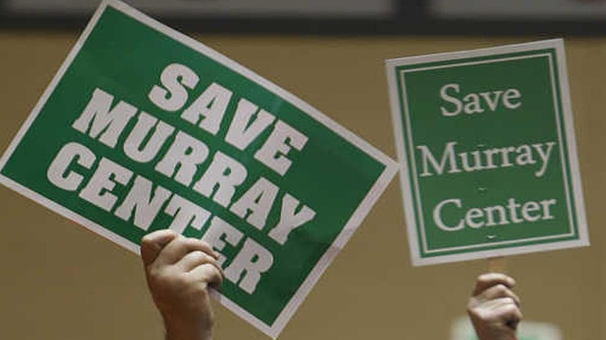 Opponents of the proposed closure of Murray Center waved signs during a public hearing.