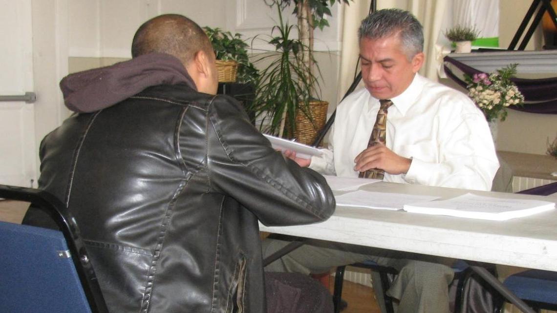 
Illinois Parole Board member Adam Monreal helps an attendee at a workshop on expungement of criminal records.
