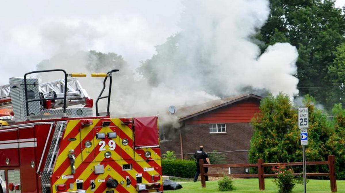 
Gray smoke billows from the roof of an apartment building on Lakeshore Drive in Belleville Wednesday. One of the upper units of the building was gutted by the fire and its occupant transported to the hospital.
