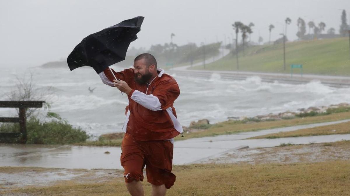 Matt Looingvill struggles with his umbrella as he tries to walk in the wind and rain, on Friday in Corpus Christi, Texas.