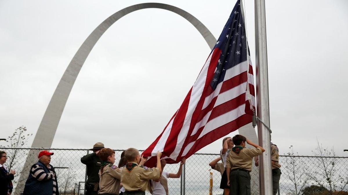 Area boy and girl scouts raise a flag during a ceremony to mark the 50th anniversary of the completion of the Gateway Arch on Wednesday, Oct. 28, 2015, in St. Louis. Several hundred people turned out in downtown St. Louis to celebrate the moment the iconic monument was completed a half century ago.