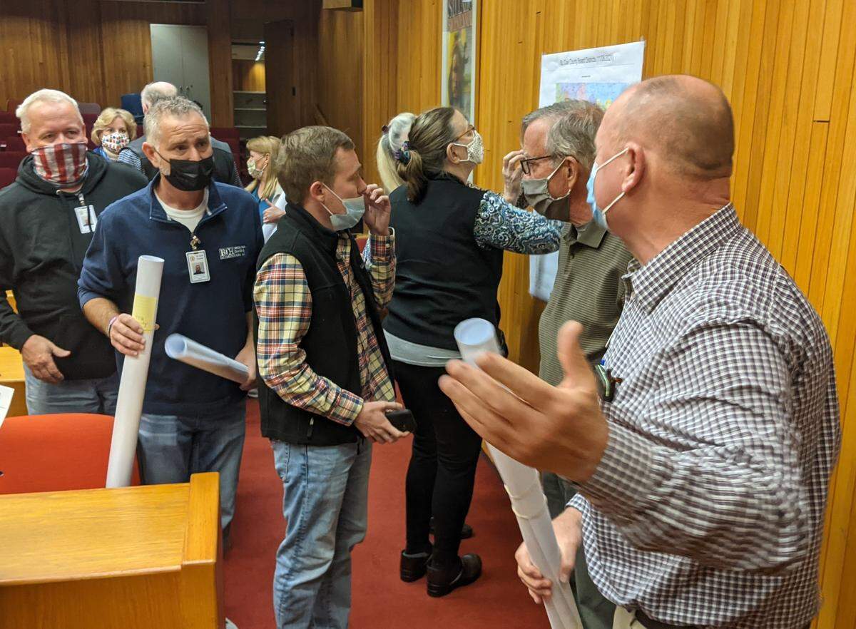 St. Clair County Republican board members and their constituents gather around a copy of the county redistricting map at a board meeting in November. Republican board member Ed Cockrell said the map is “party preservation at its finest.”