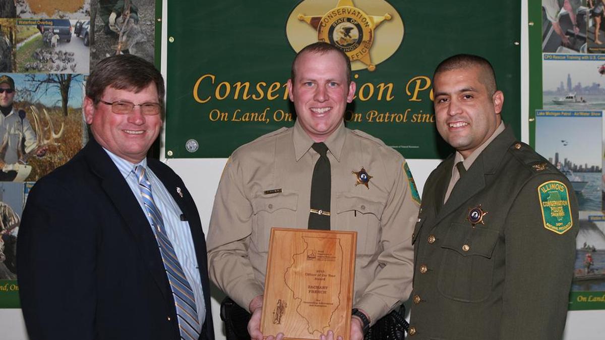 Illinois Conservation Police Officer Zachary French was named Illinois Conservation Police Officer of the Year on Friday, April 15. Presenting CPO French with his award are Illinois Department of Natural Resources Director Wayne Rosenthal, left, and IDNR Conservation Police Chief Rafael Gutierrez.