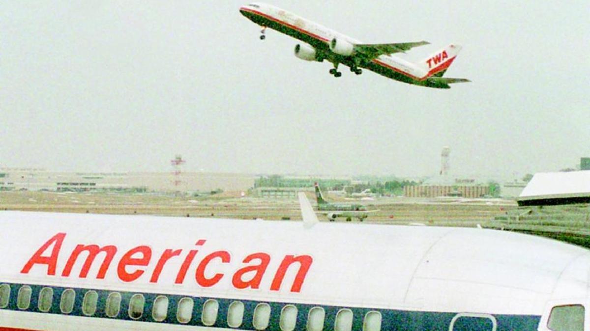 In this file photo, an American Airlines jet sat in a parking slot as a TWA plane took off at Lambert-St. Louis International Airport.