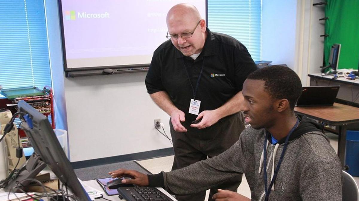 In a visit to Belleville East in 2014, Lancer graduate Bill Fink talks with senior Don Proctor about a website that Proctor helped design. Fink spoke to the students about careers in technology.