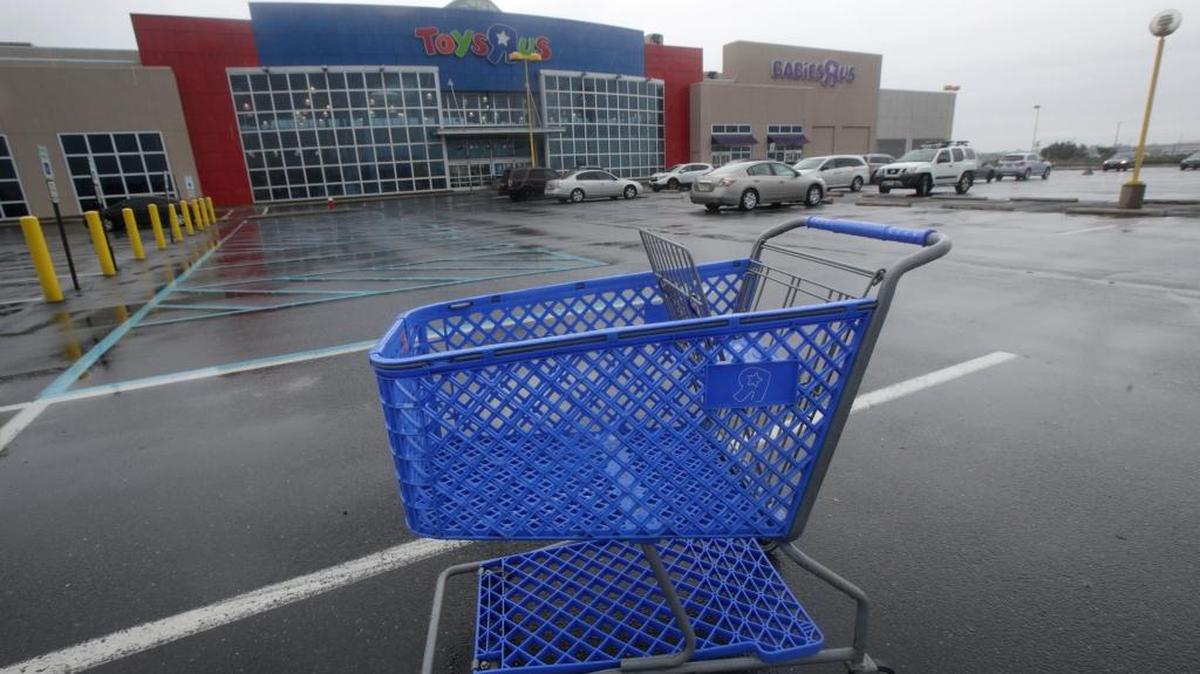A shopping cart is seen in the parking lot of a Toys R Us store. Toys R Us may be closing at least 100 stores across the U.S.
