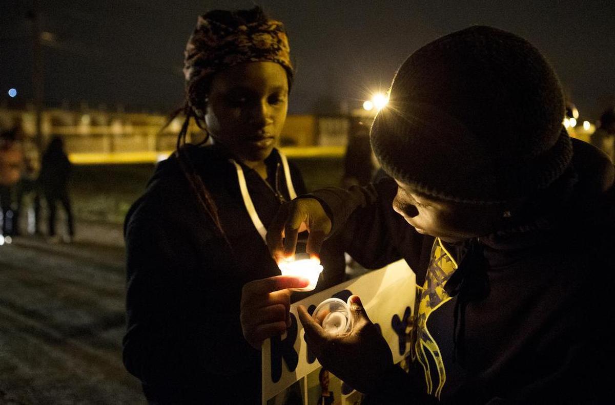 Jaylon Dennis helps Demario Redmond light his candle. Friends and family of Johnnie Brim celebrated his life on his birthday with a vigil that ended where he was shot on New Year’s Eve in 2015.