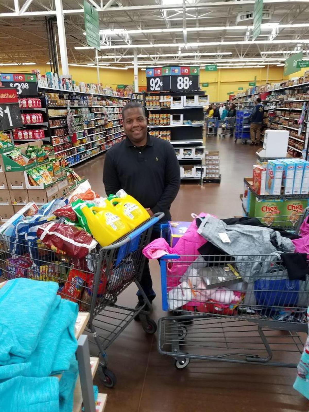 Illinois State Trooper Calvin Dye Jr. fills shopping carts with supplies for the Williams family.
