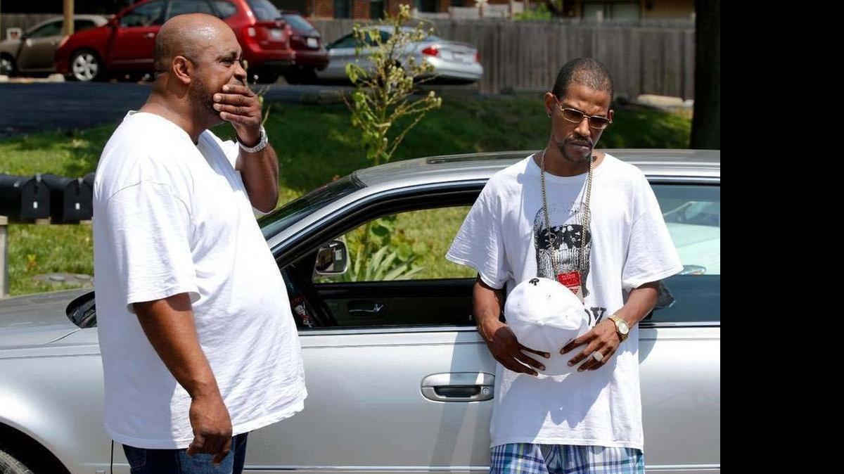 
Richard Baker, left, and Gover Gillespie III talk outside the Shiloh apartment building where Kenneth J. Easley was killed Saturday.
