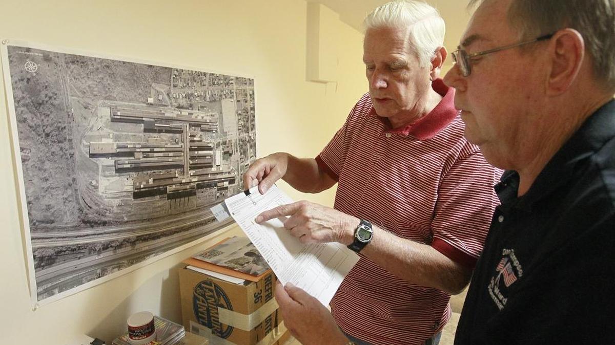 Retired Dow Chemical Company workers Bill Hoppe, left, and Don Thompson look over lists of radioactive elements that were checked while they worked there.