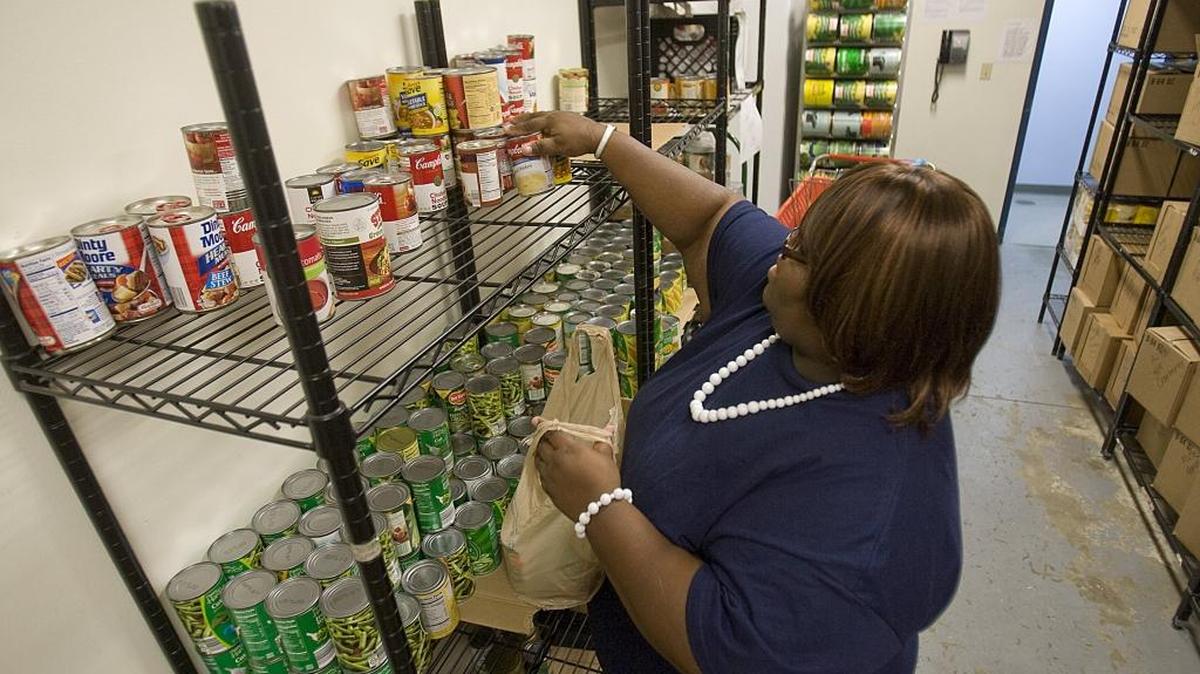 Salvation Army volunteer Rachelle Johnson of Belleville reaches for canned goods on a shelf at the Belleville Salvation Army’s food pantry.