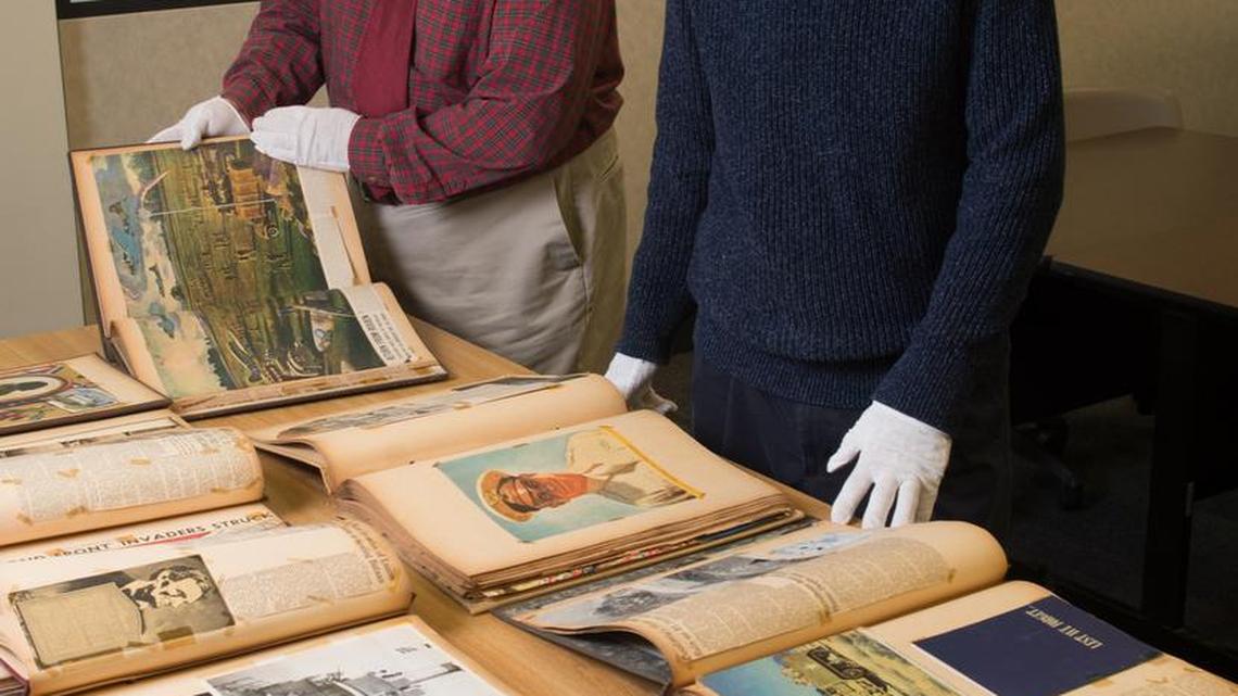 University archivist and special collections librarian Stephen Kerber (front) and LIS history subject liaison Matt Paris (back) view the extensive set of scrapbooks dating from the 1940s that have been donated to SIUE’s library archive. The scrapbooks serve as a “1940s news aggregator,” according to the university, showing how people on the homefront were informed about World War II. The Wilton Collection will be available for researchers in early 2018.