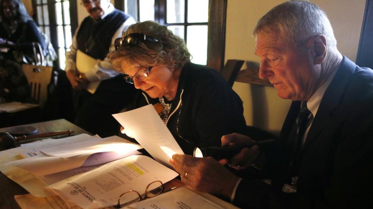 From left: Dixie Seibert and Jerry Dinges use flashlight to read during public safety meeting held inside the dimly lit Historic Cahokia Courthouse in 2015. The event was part of the celebration of the 225th anniversary of St. Clair County.