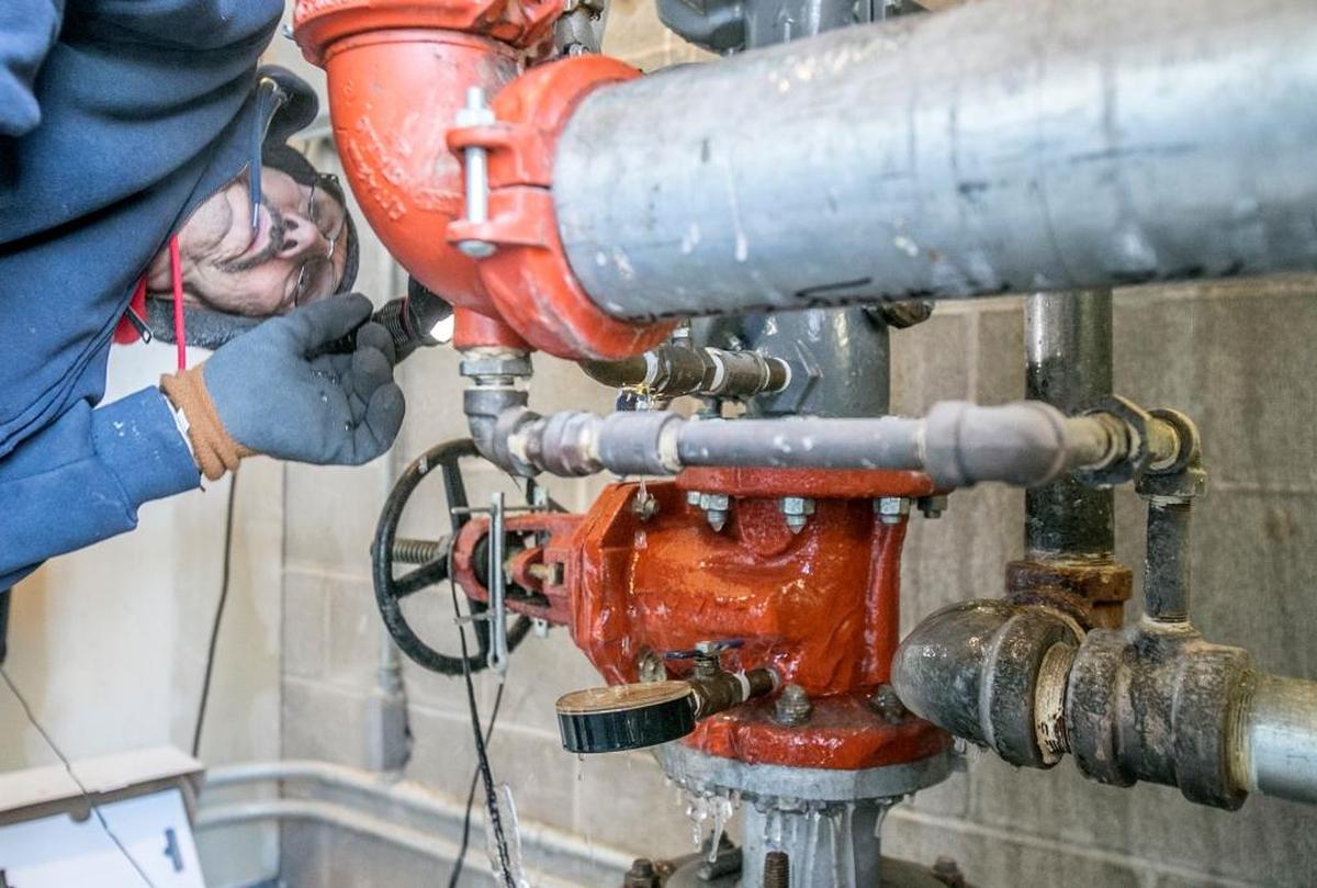 Plumber Jim Hutchings, with Embrich Plumbing Co. based in Maryville, looks for the source of a leak on a frozen water line that is part of a sprinkler system at a commercial business in Fairview Heights on Tuesday. A frozen meter appeared to be broken due to the extreme cold. The service area did not have heat turned on.