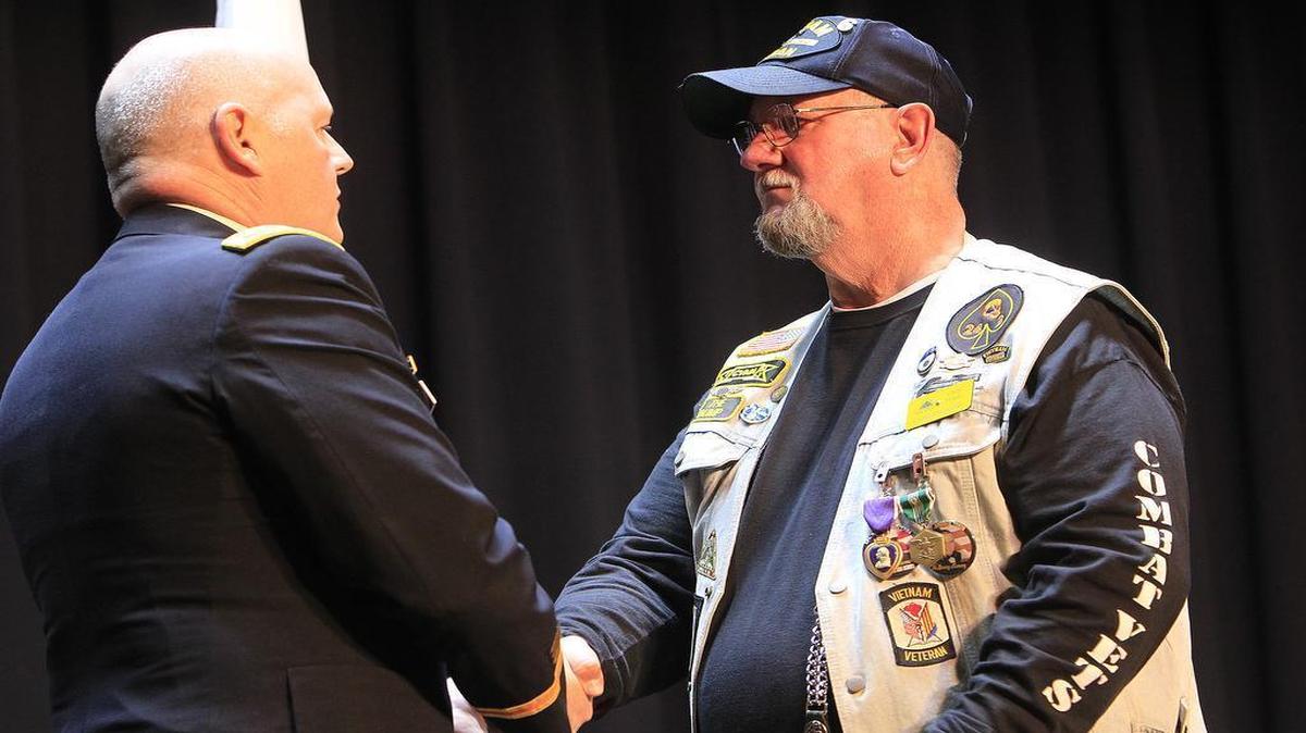 Vietnam veteran Cecil Wade shakes hands with U.S. Army Col. Kevin Lynch during a ceremony at Scott Air Force Base, where Wade received medals from his time in service. Wade rode his motorcycle onto the base with members of the Patriot Guard and the Combat Vets Motorcycle Association, to the library auditorium where he received a Purple Heart medal, the Army Commendation with Valor medal, and a second Battle Star on his Vietnam Service Medal from Lynch.