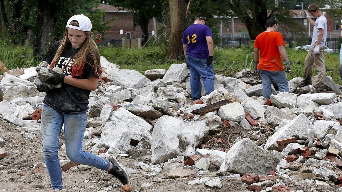
World Changers volunteer Madison Sebatian, 14, of Louisville, Kentucky carries rocks along with other volunteers who were helping clear a lot owned by the nearby Christian Activity Center in East St. Louis.
