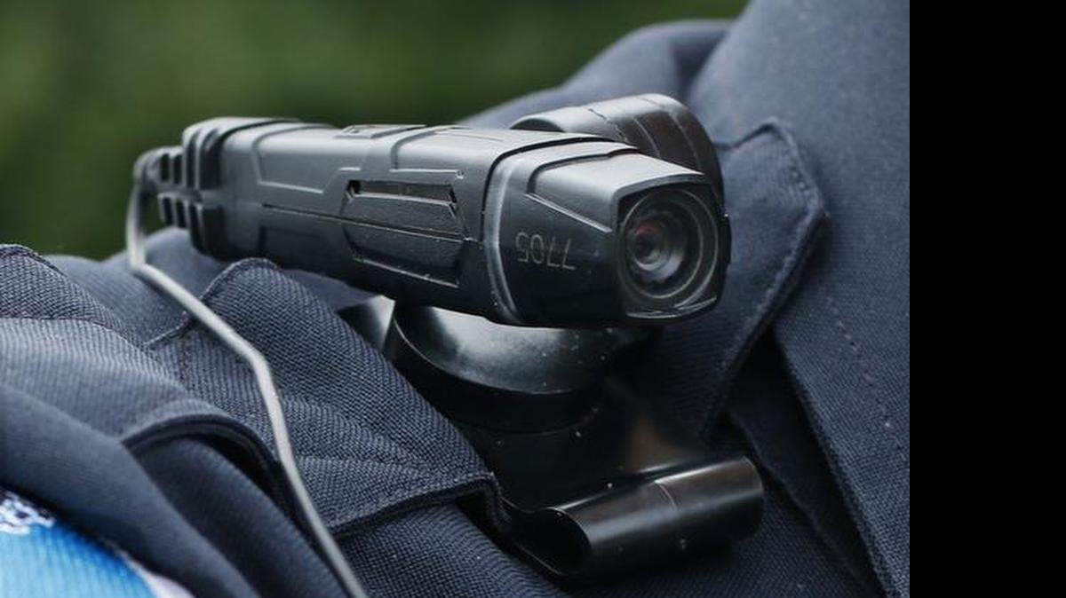 
Detail photo of the small, slim lapel-mounter Tazar brand officer body camera worn by a police officer in North Carolina over his right shoulder while on duty. The town’s police department issued body cameras to patrol officers last year. 
