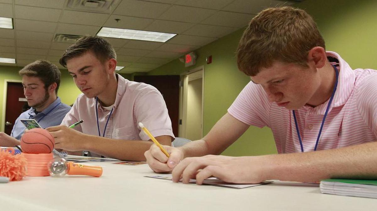 
From left: Alan Plantz, Belleville West; Erik Faulkner, Belleville West; and David Rauckman, Belleville East; work on an exercise during their CEO training program. 
