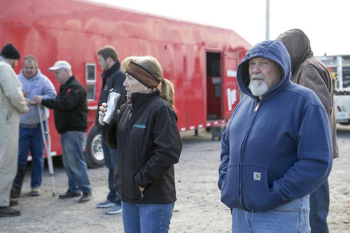 Danny McClaskey, right, and friend Kim Sampson watch as McClaskey Feed Co. equipment and vehicles are auctioned on Wednesday morning in rural Collinsville as part of a bankruptcy case.