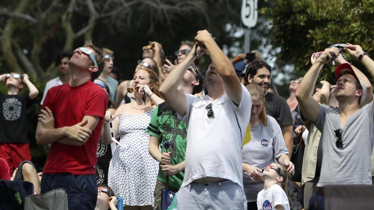 A crowd gathered in a Carbondale City park near the Shadow Fest live music stage Monday afternoon watch the solar eclipse.