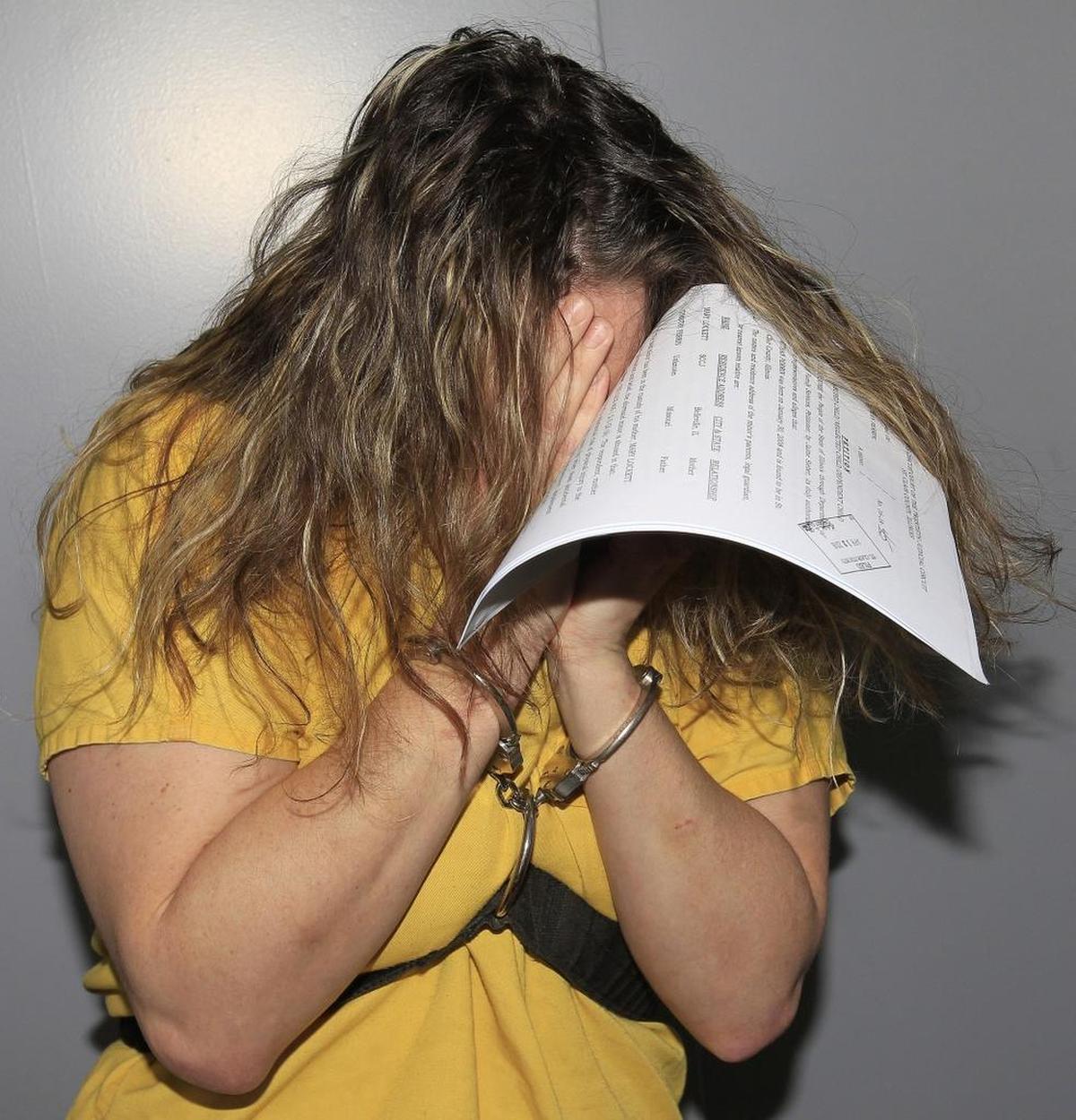 In this April 2017 photo, Mary Lockett kept her face covered in the prisoner transport elevator at the St. Clair County Building where she appeared for arraignment on charges of first-degree murder in the suffocation death of her daughter Emily Rose Perrin, 4.