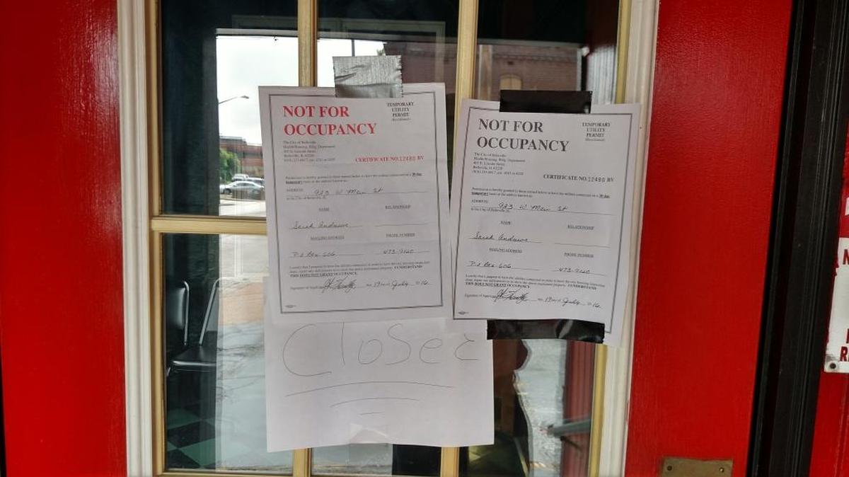 A sign reading “closed” and temporary utility permits are taped to the entry door of The Red Onion, a restaurant located at 923 W. Main St. in Belleville.