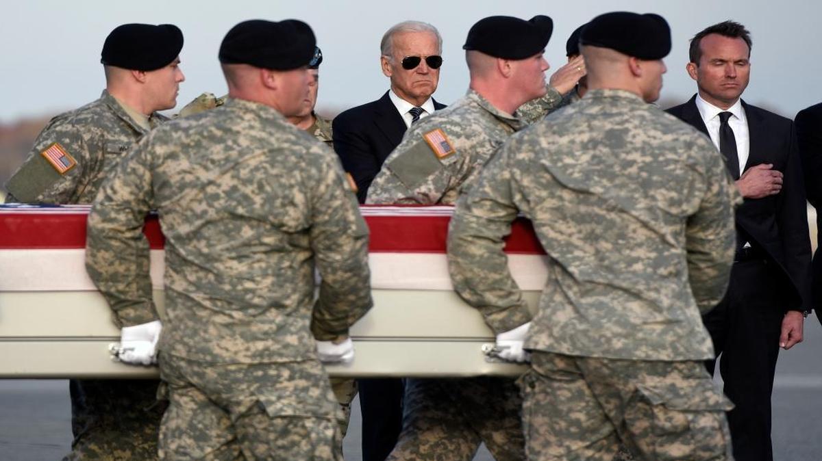 Vice President Joe Biden, center, and Army Secretary Eric Fanning, right, stand as an Army carry team moves a transfer case containing the remains of Pfc. Tyler R. Iubelt at Dover Air Force Base, Del., Tuesday. According to the Department of Defense, Iubelt, 20, of Tamaroa, Ill., died Nov. 12 of injuries sustained from an improvised explosive device in Bagram, Afghanistan, while supporting Operation Freedom's Sentinel.