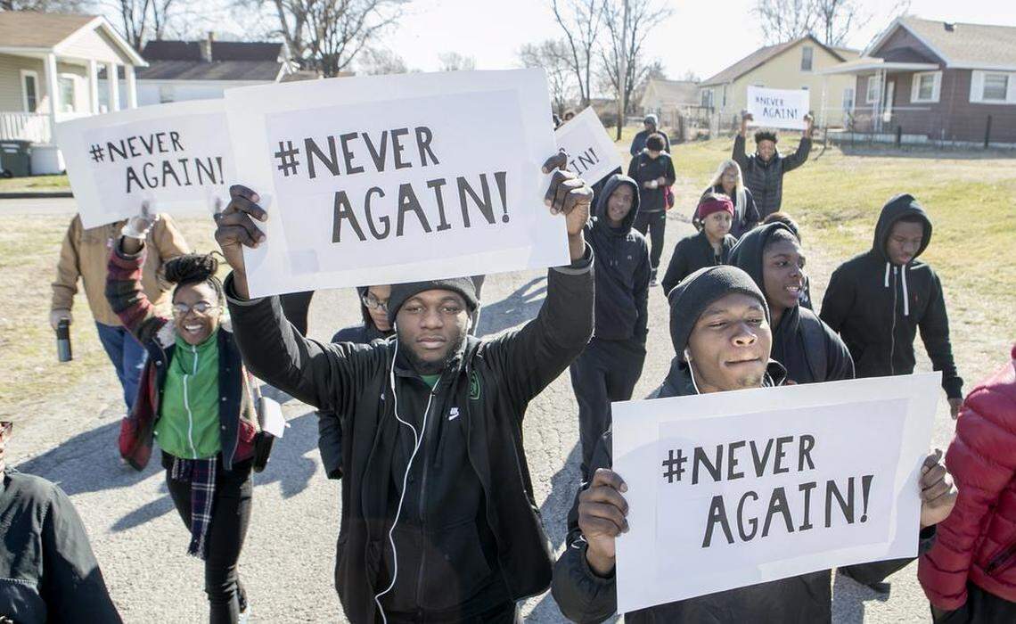 Jahanna Gillespie, Anthony Walker Jr., and Rhyheem Samuels hold signs with #Never Again as they march with other students from Madison Junior/Senior High School. The students held an organized walkout march through the neighborhood by their school.