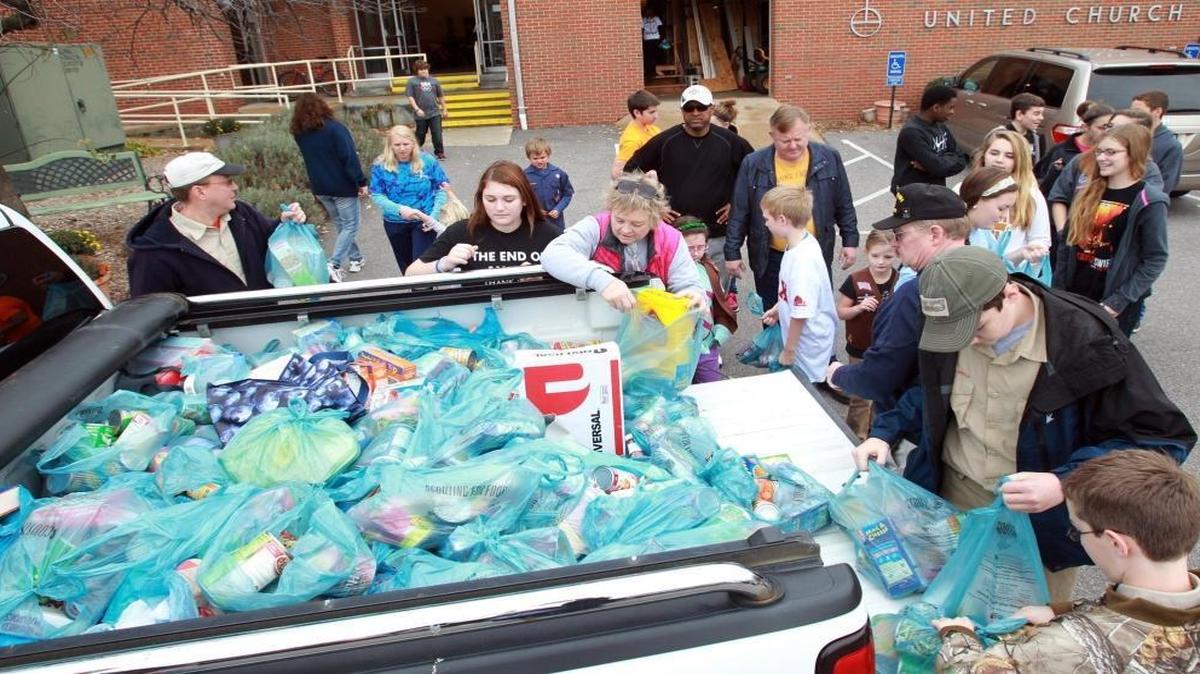 Volunteers help unload a truck of donations at St. Paul United Church of Christ in Belleville during Scouting for Food in 2013. Scouts will pickup up food on Saturday for this year’s event.