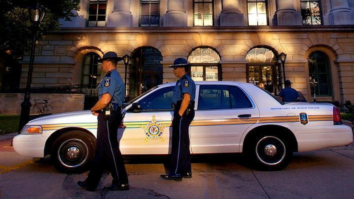 In this Sept. 21, 2004, file photo, Illinois Secretary of State Police secure the entrance of the Illinois State Capitol building after an unarmed security guard was shot and killed in Springfield, Ill. The Illinois budget foul-up took on safety implications last winter when Secretary of State Police had to make cash pickups at driver’s licenses facilities after an unpaid armored-truck company temporarily quit. Illinois Secretary of State Jesse White’s office told The Associated Press that pairs of armed police officers made the pickups during off-hours for 15 weeks.