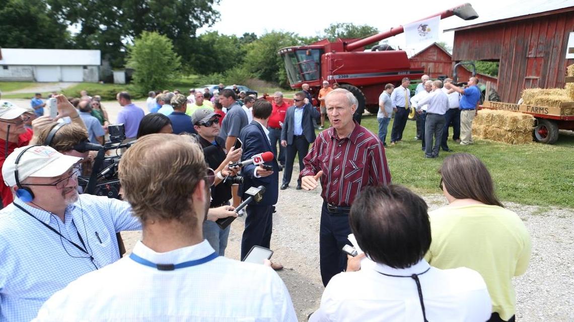 Gov. Bruce Rauner speaks with members of the media during his stop at the Tiedemann farm, located outside Belleville. The stop on Wednesday, July 27, 2016, was part of a statewide tour promoting term limits and legislative redistricting reform. The recent campaign-style events offer a preview of how the Illinois candidates Rauner is financially backing will approach their races.