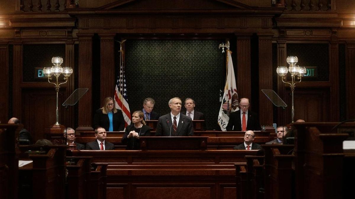 In this Wednesday, Feb. 17, 2016 photo, Illinois Gov. Bruce Rauner, center, delivers the State of the Budget Address to a joint session of the General Assembly in the House chambers at the Illinois State Capitol in Springfield. In the latest chapter in Illinois’ seemingly never-ending budget saga, Republican Gov. Bruce Rauner urged lawmakers to make a choice now: Pass reforms he wants in exchange for a $36 billion budget, which would include raising taxes, or allow him to cut $3.5 billion from the spending plan however he chooses.