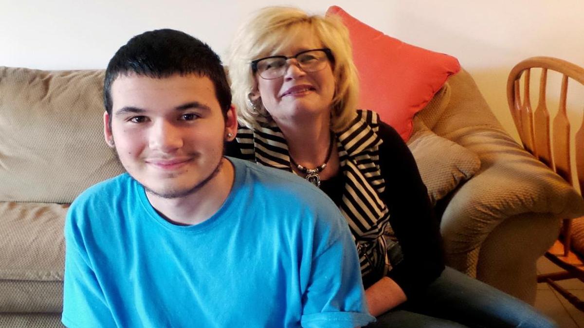 In this May 4, 2016, photo, Philip Graceffa poses for a photo with his mother, Cynthia, at her home in Rockford, Ill. Graceffa recently finished the Redeploy Illinois program, which gives juveniles an option based in the community, instead of prison. Several Redeploy programs around the state are being cut because of the state budget impasse. Phillip says the program helped turn his life around after several bad decisions. He’s now working at a local fast food restaurant, completing his high school equivalency and dreams of being a firefighter someday.