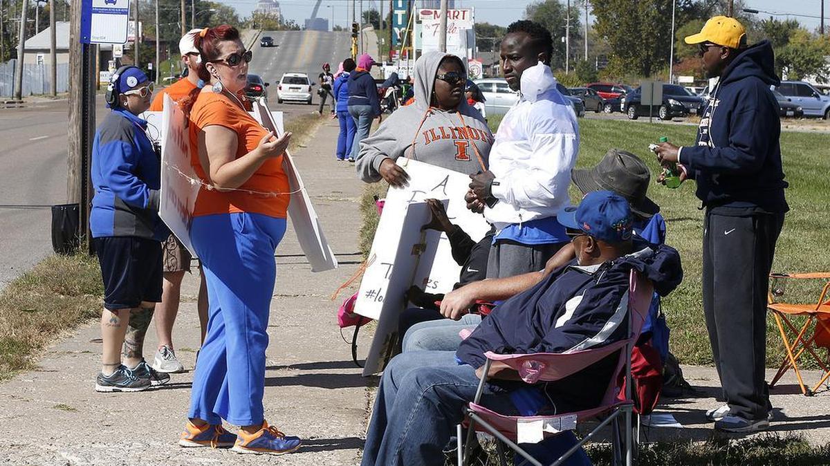 
Strikers continue to march and sit on the sidewalk Tuesday in front of East St. Louis Senior High School. 
