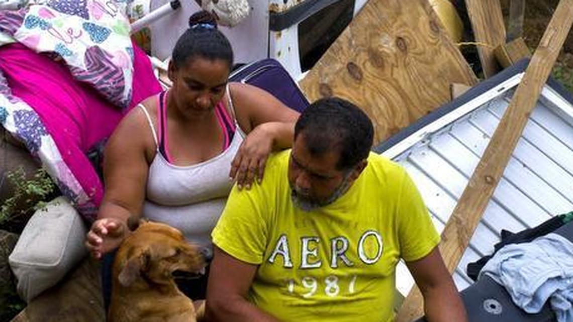 Yadira Sortre and William Fontan Quintero with what is left of their belongings, destroyed by Hurricane Maria. Their children build a room to protect themselves from the elements in the San Lorenzo neighborhood of Morovis, Puerto Rico.