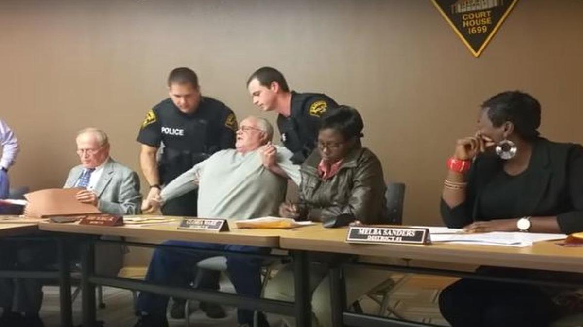 Police remove Trustee Jerry Nichols from the Cahokia Village Board meeting Tuesday night.
