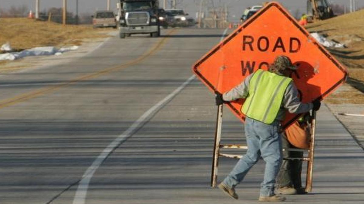 Workers remove the construction signs on Frank Scott Parkway in 2008. Work has been in phases, with construction on the final 2.5-mile stretch to Scott Air Force Base expected to begin in 2018.
