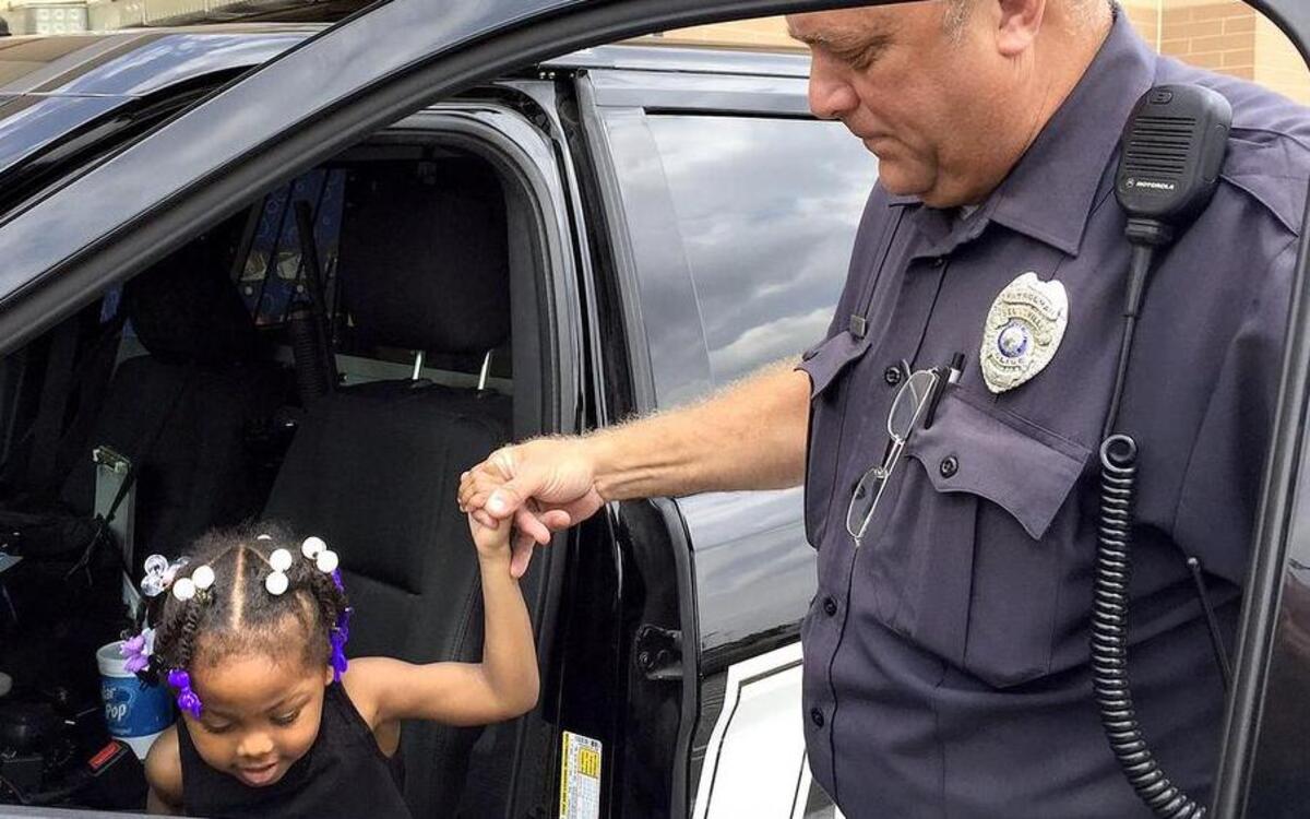 Amani McCallmon, 3, of Belleville gets a hand from Belleville Police officer Mark Eschman after giving a tour of his patrol car in the Belleville Walmart parking lot. McCallmom’s mother was chatting with officer Eschman when Amani jumped at Eschman’s offer to let her sit in the front seat for a minute.