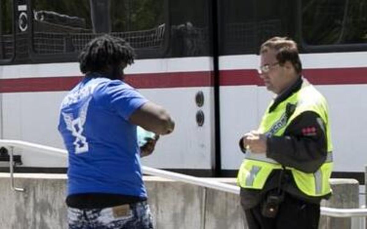 A Metro security guard checks tickets at the Fairview Heights MetroLink station. A $3.6-million study will help decide whether barriers and turnstiles will improve security on the mass transit system.